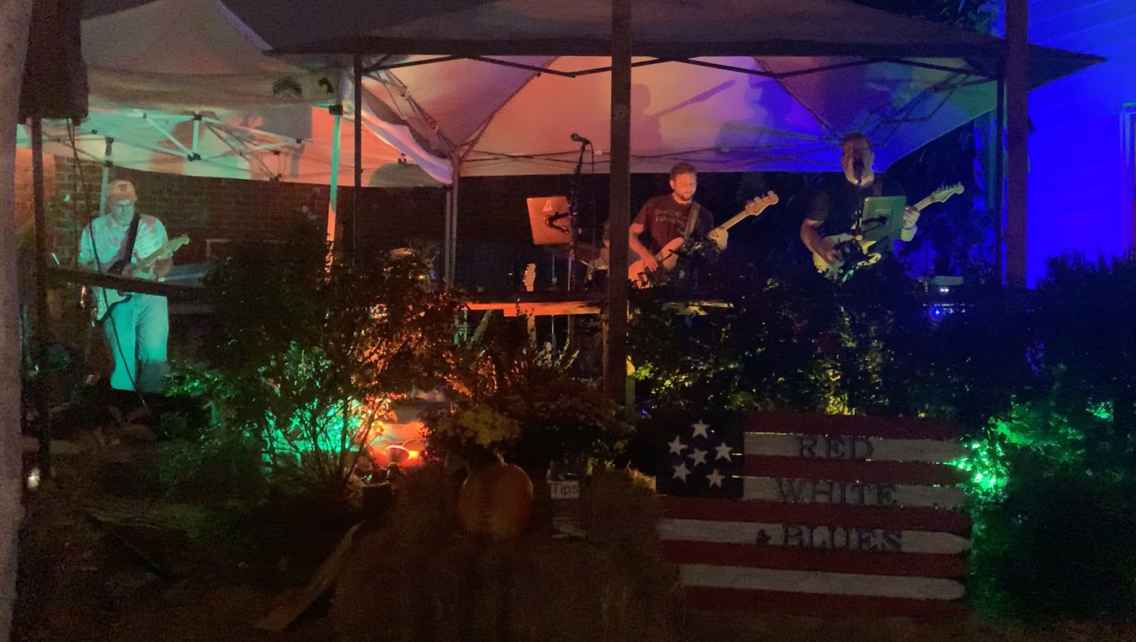 The band playing an outdoor stage at night